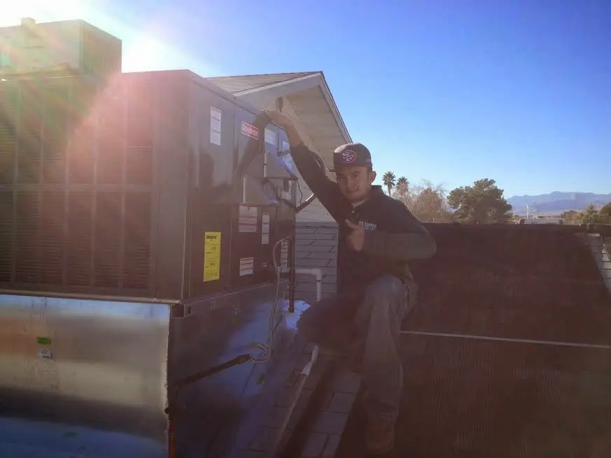 HVAC technician performing Boiler Repair on a rooftop unit in Algonquin